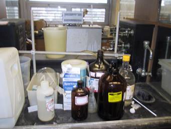 Photo of waste chemicals and other debris left at lab station