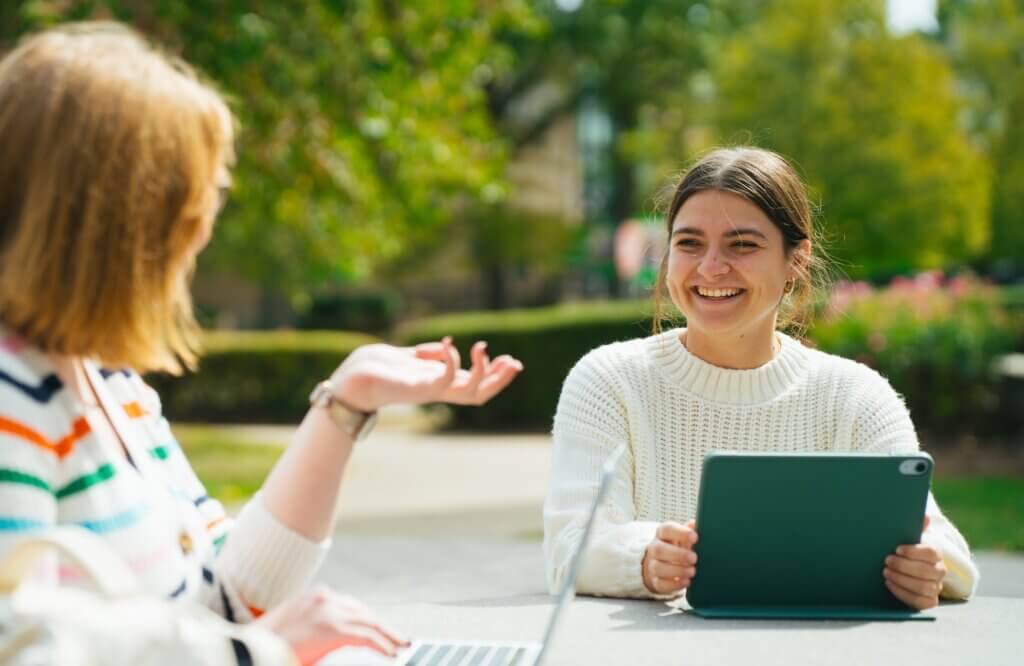 two students talking outside on campus