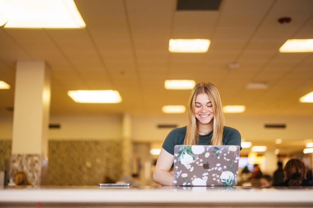 student working on a laptop in the library