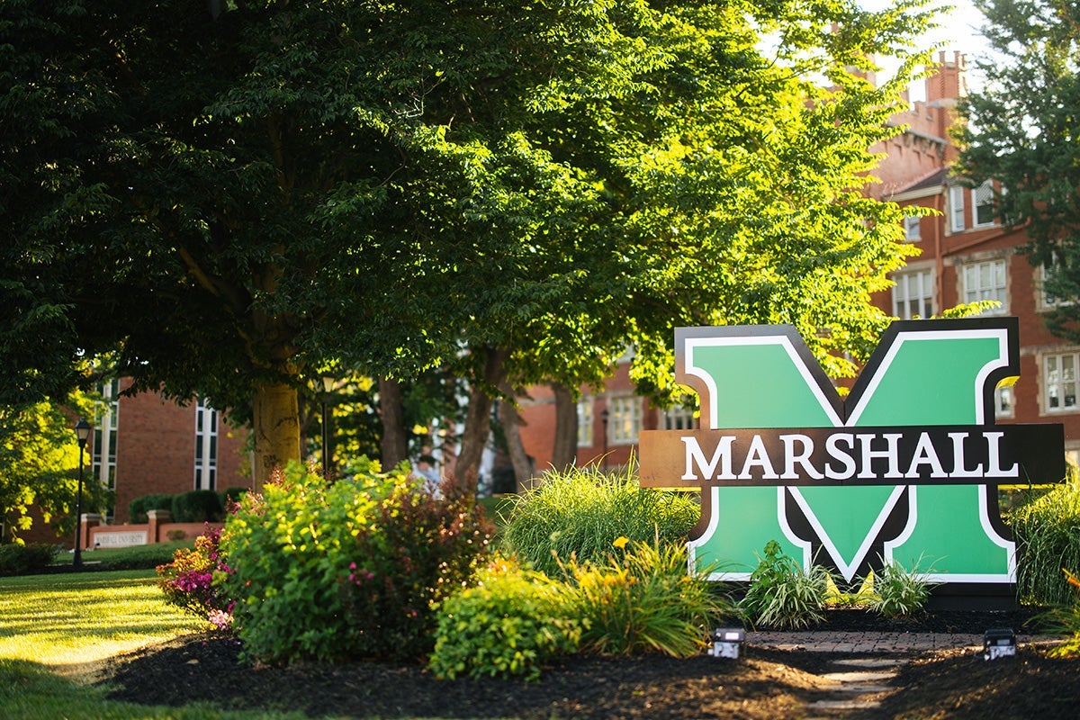 A Marshall sign surrounded with trees and landscaping on Marshall University's Huntington campus