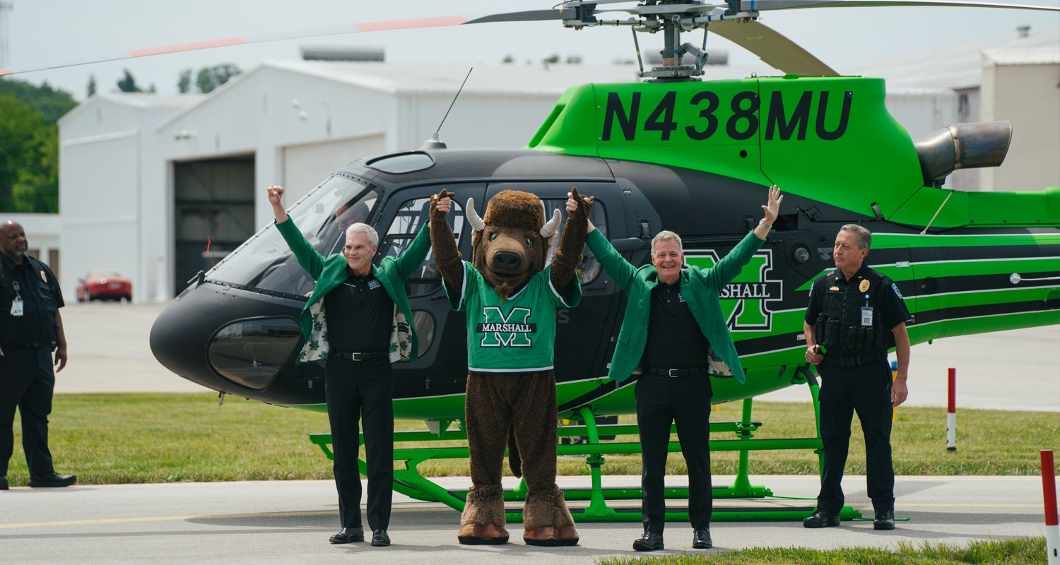 Marshall University president, Brad D. Smith, Marco and Bill Noe, Marshall University's Chief Aviation officer join heads in celebration of the delivery of Marshall's new branded helicopter