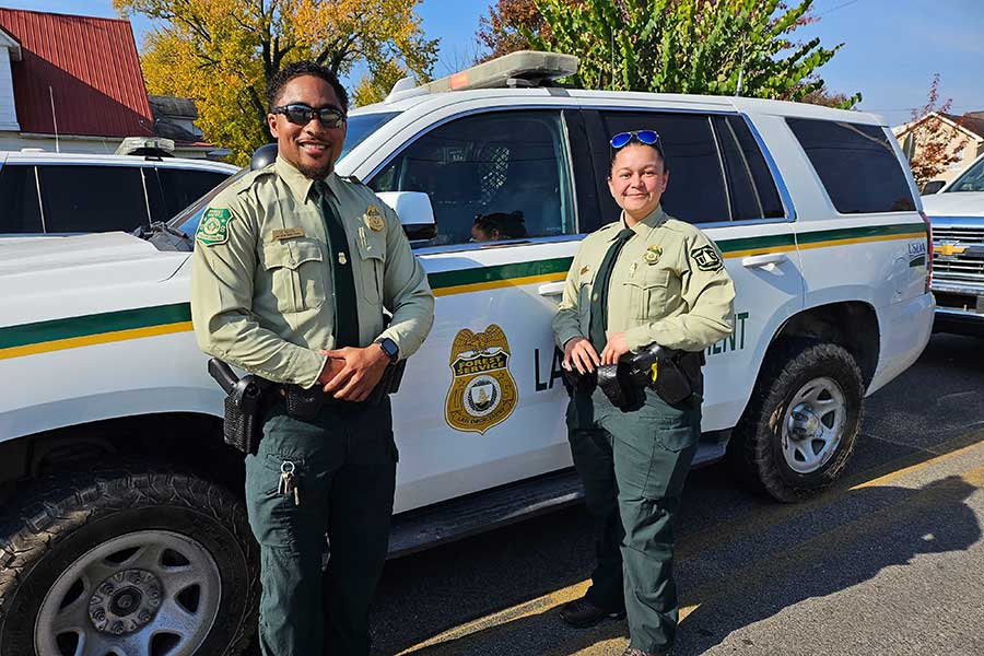 Forest Service Law Enforcement officers standing in front of their service vehicle