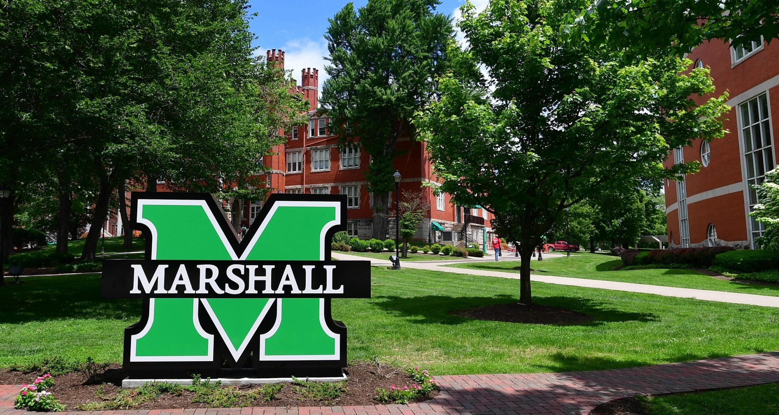 Marshall block M logo in front of Old Main on campus