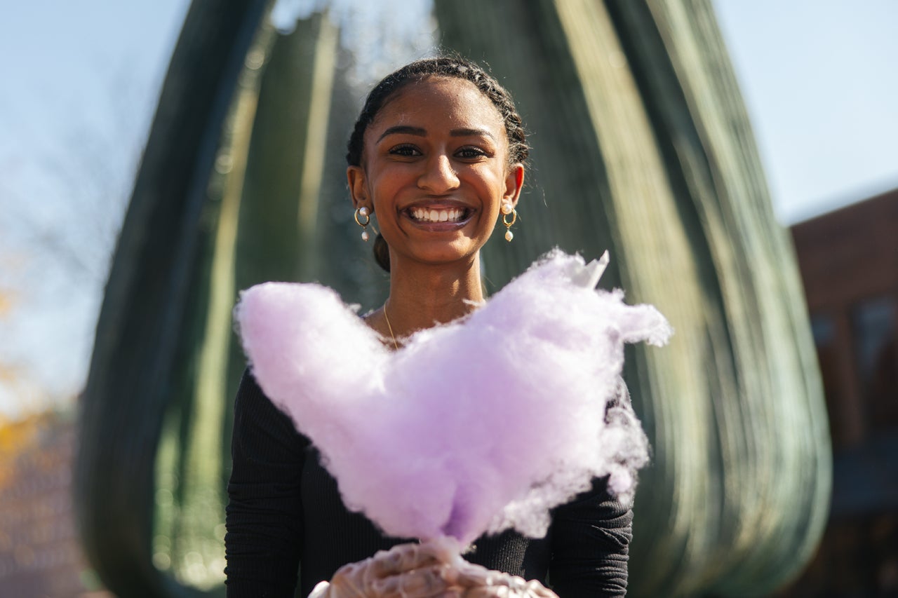 Student with heart shaped cotton candy on the Marshall University student center plaza