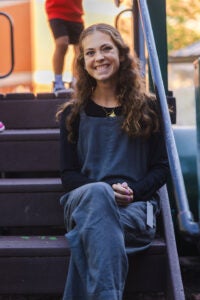 Abby Herring sits on the steps of the playground at Marshall University's Early Education STEAM Center