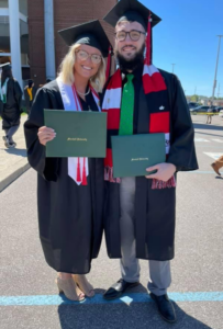 Cody Stiltner pictured with his wife in their caps and gowns, holding their diplomas, following commencement. 