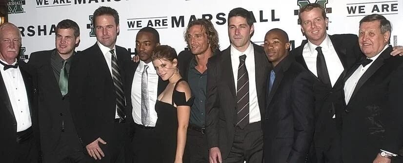 Members of the cast and crew smile together at the movie premiere of We Are Marshall