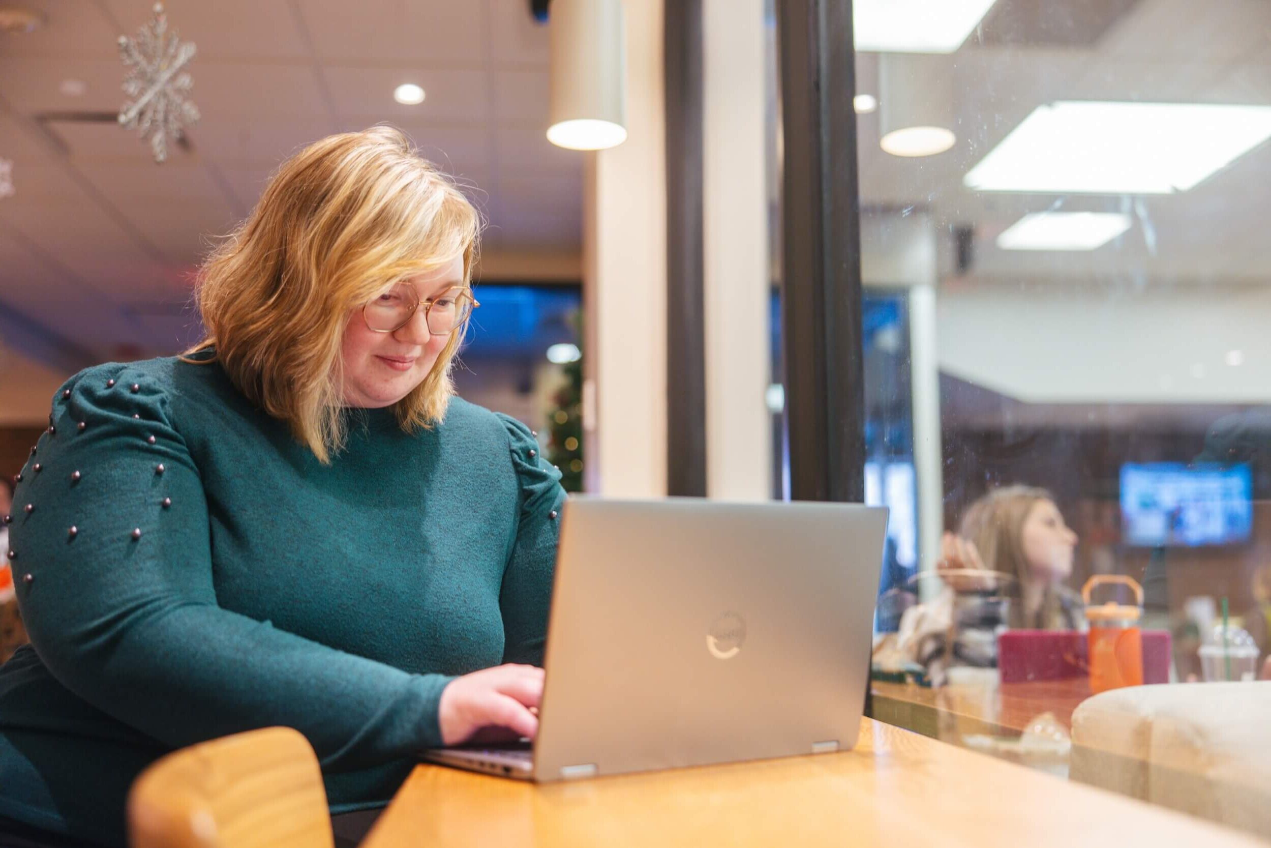 student working on a laptop inside