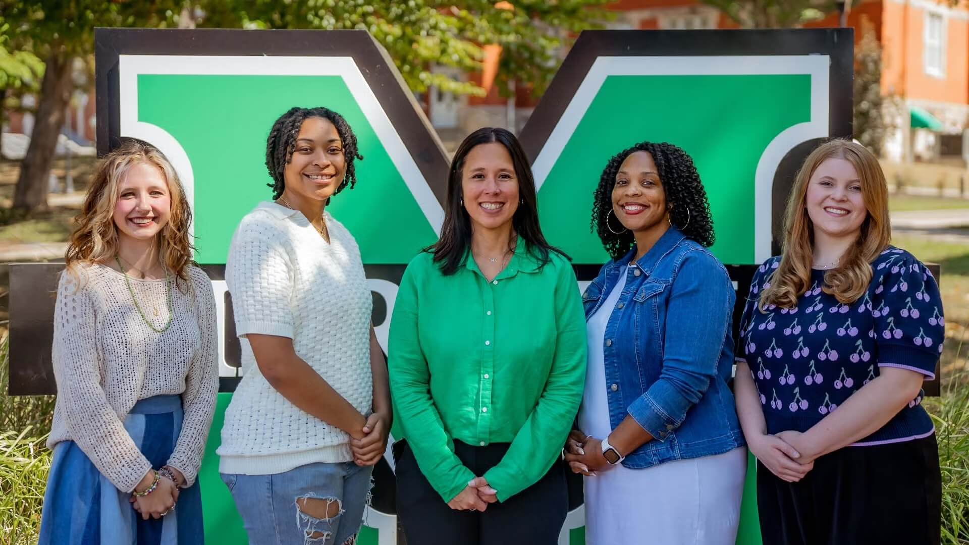 photo of five people in front of Block M on campus