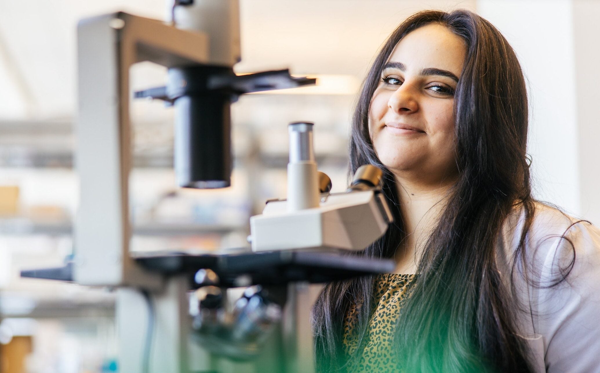 student in a lab with a microscope