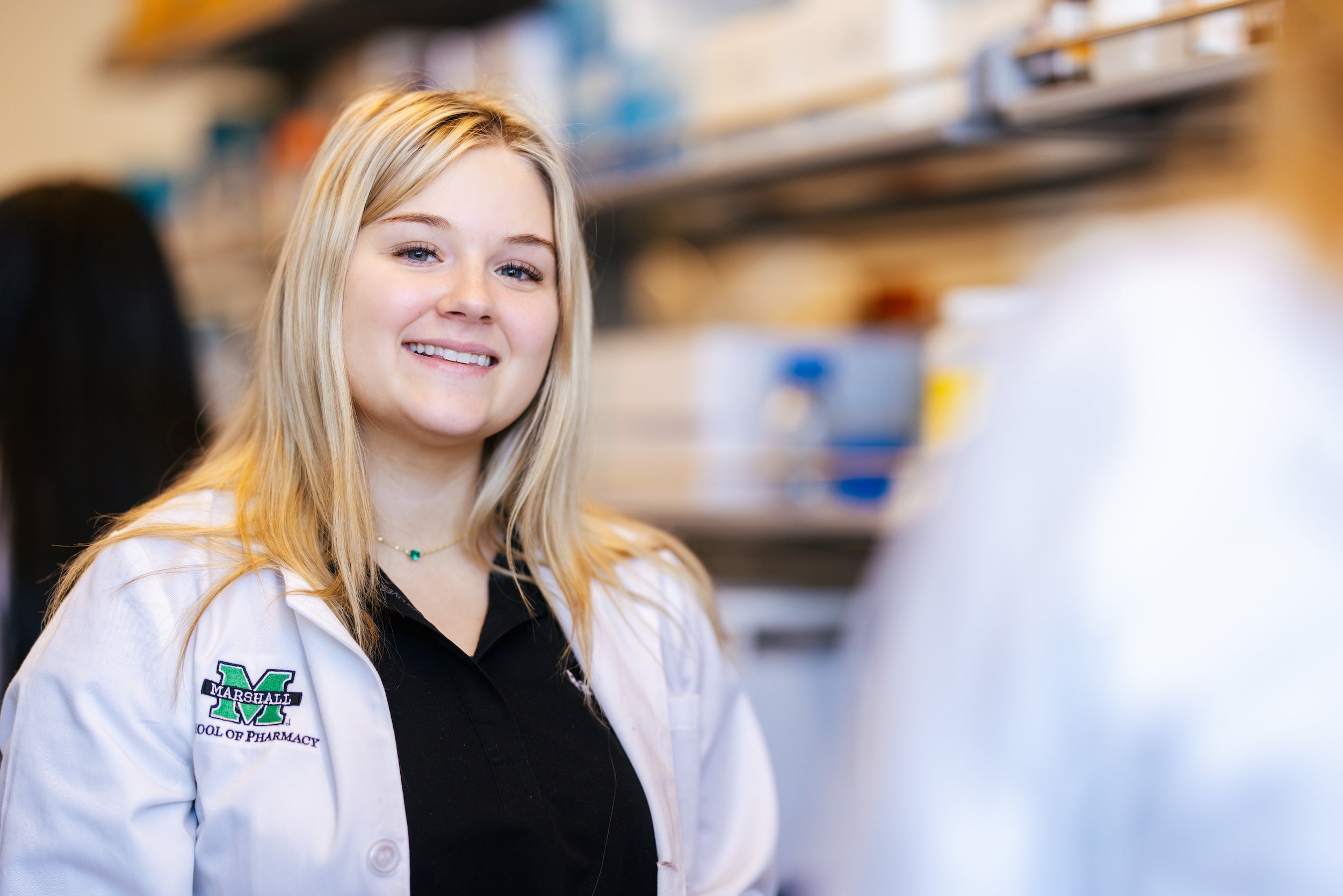 student smiling in a pharmacy lab