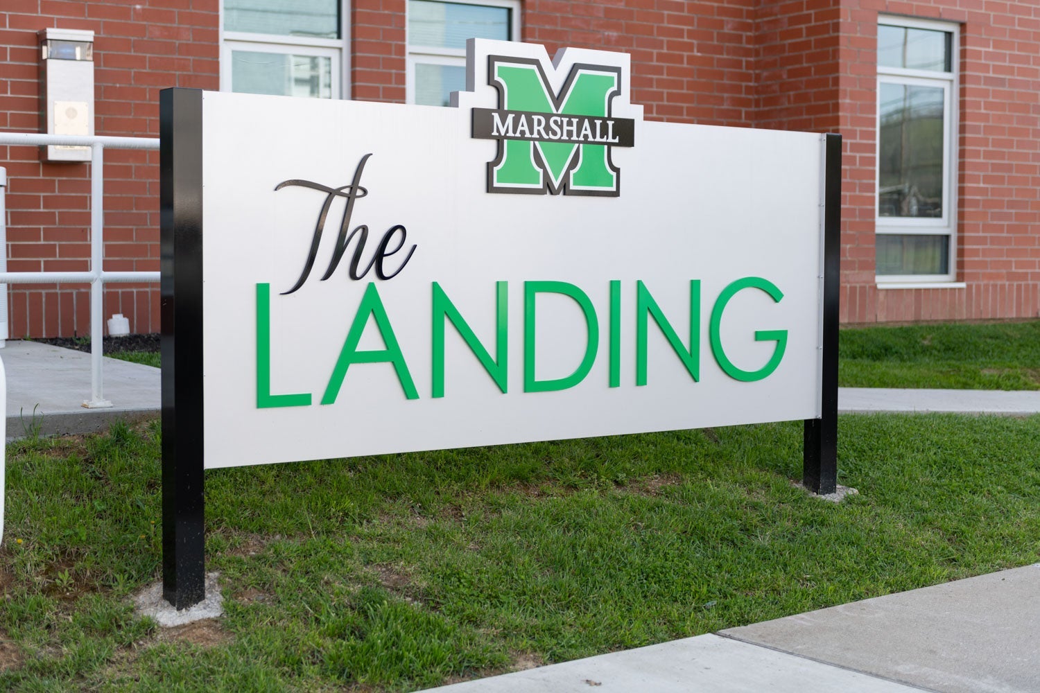 Sign reading The Landing with Marshall University logo