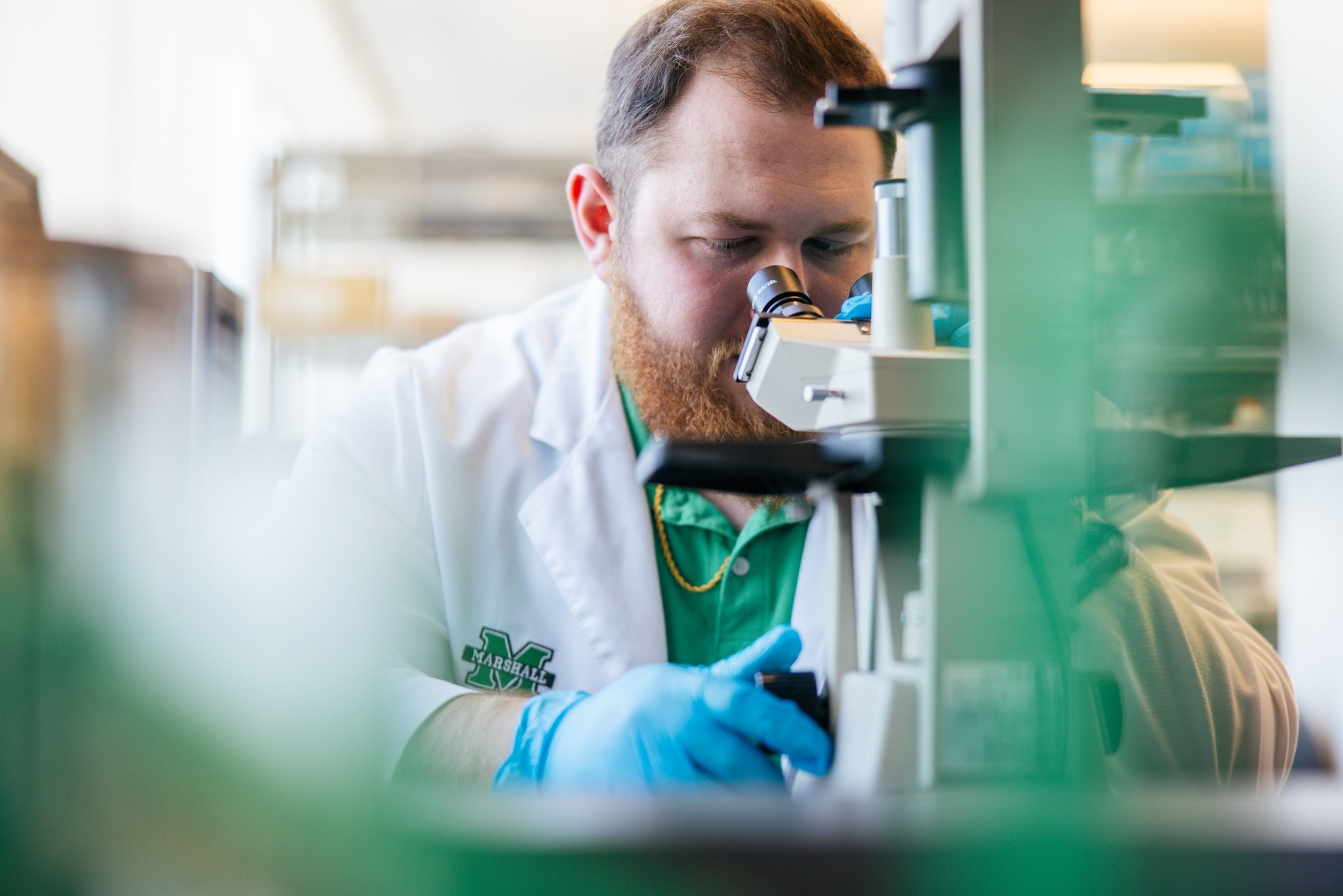 student looking through a microscope in a lab