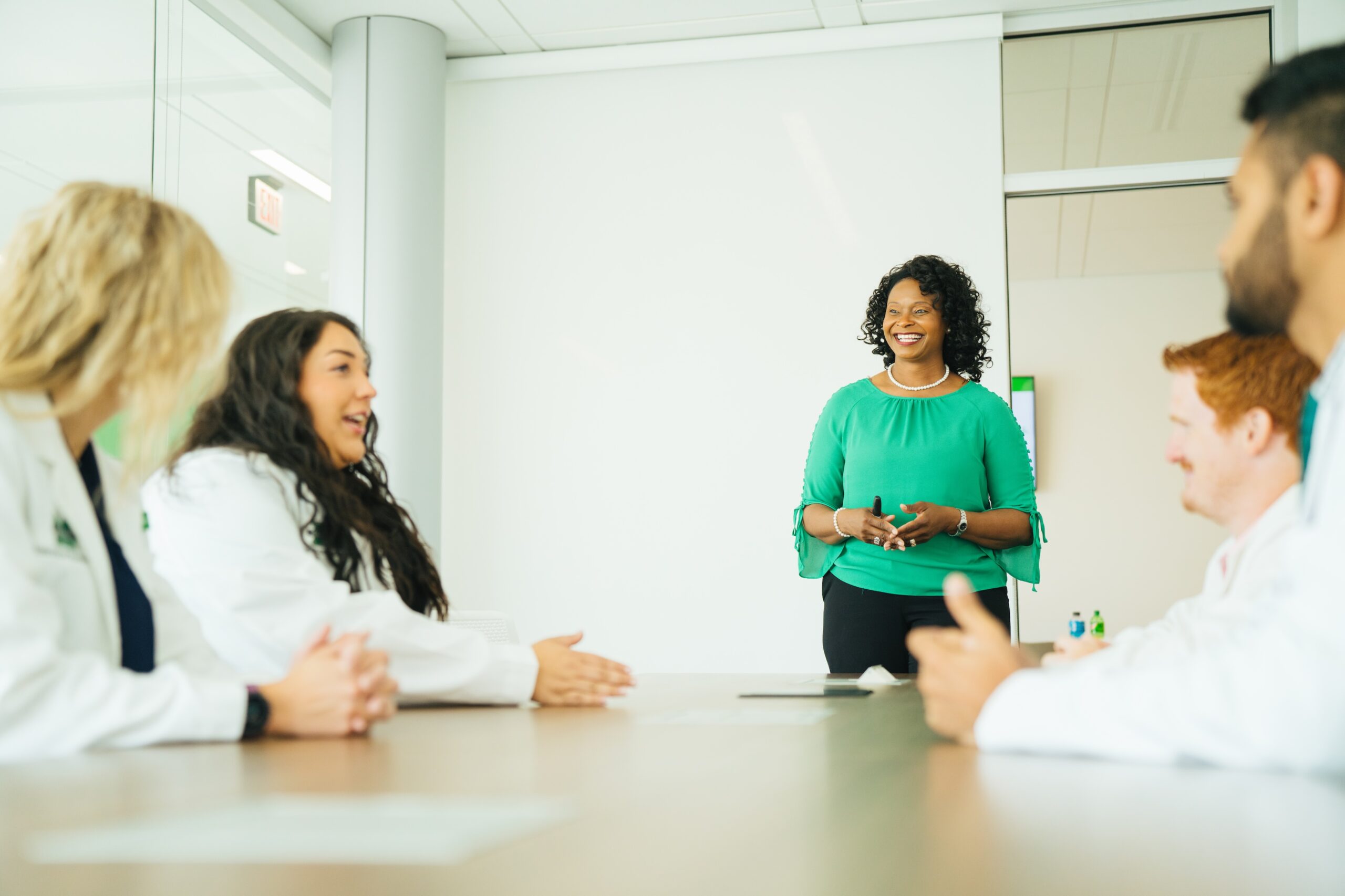 four pharmacy students talking with a pharmacy professor