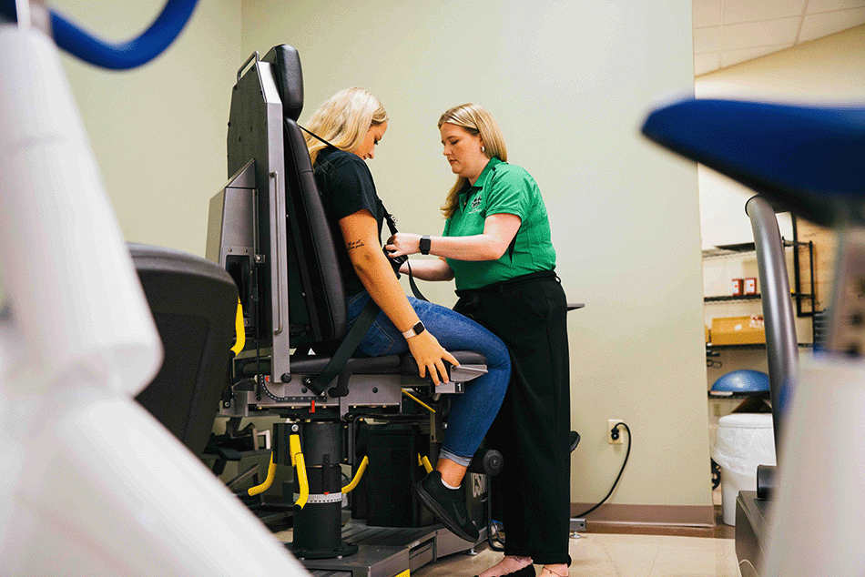 physical therapy student performing test on patient sitting in a chair