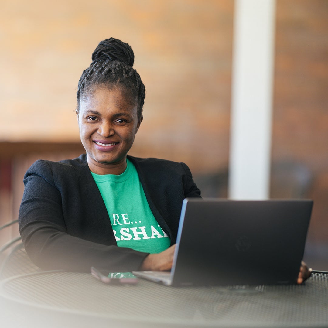 Student wearing a Marshall shirt while working on a computer