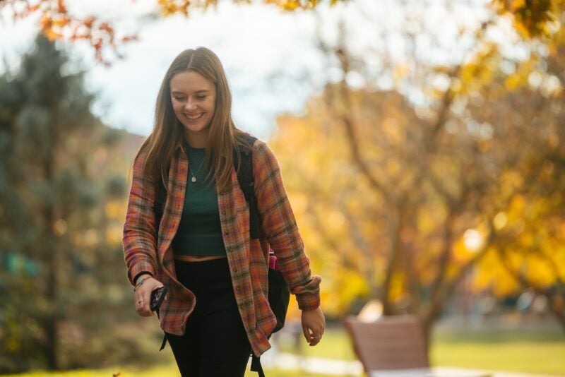 student smiling and walking to class