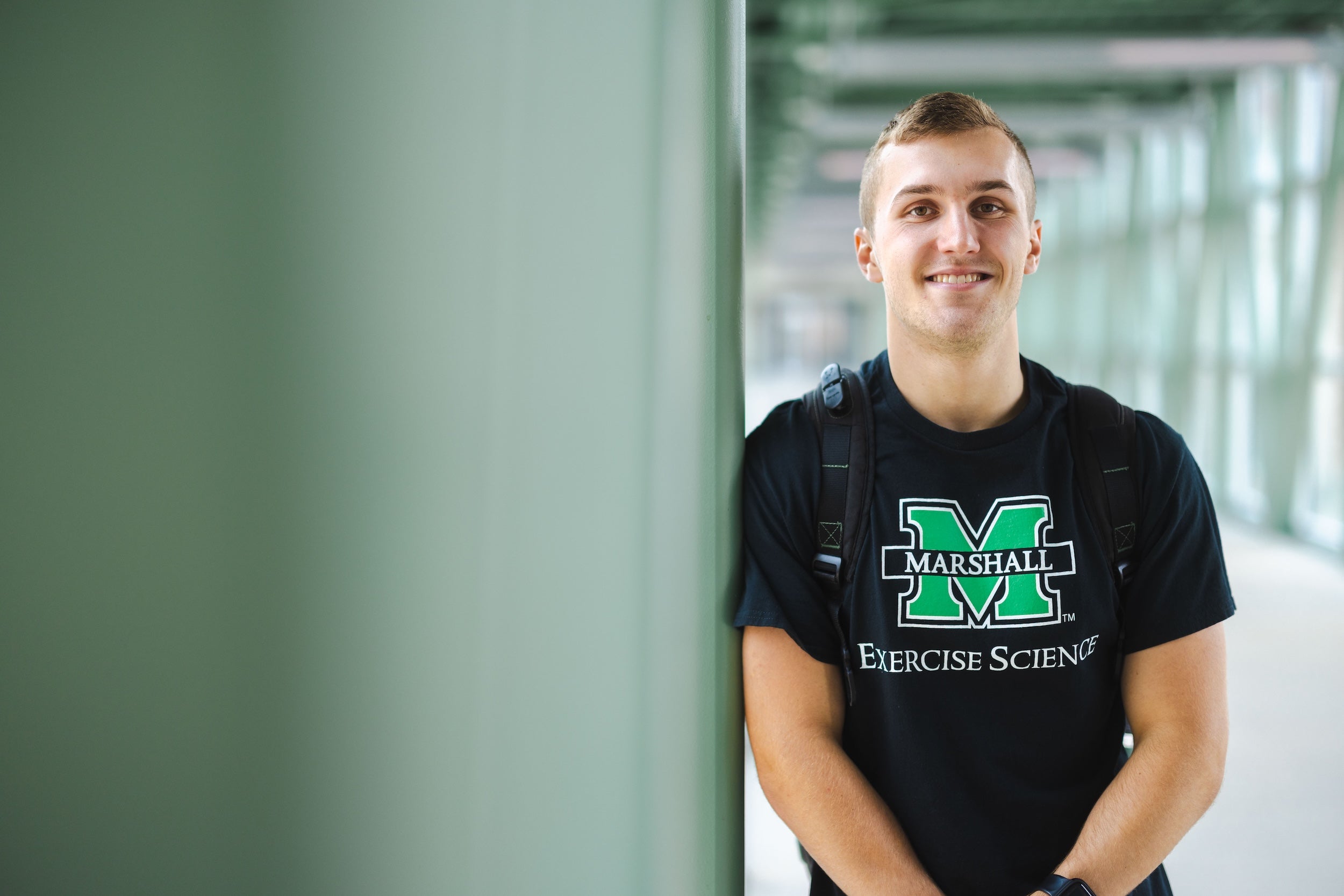 student in a Marshall shirt smiling at the camera