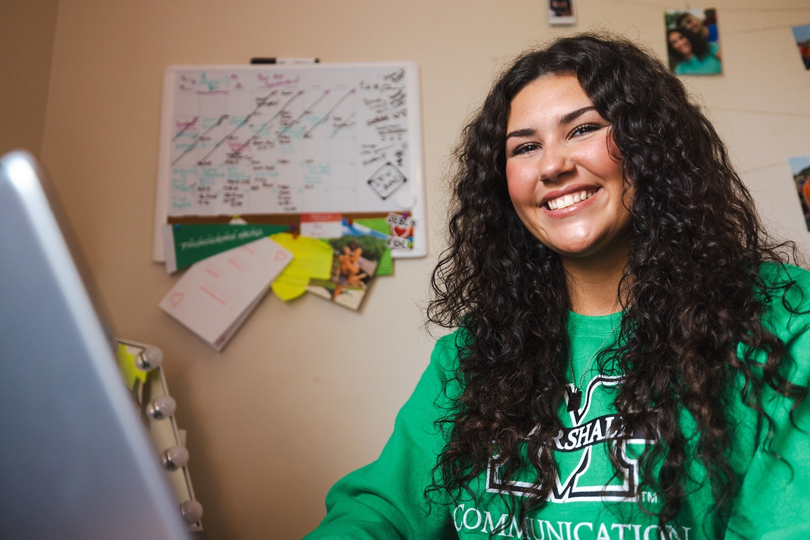 student smiling at the camera at desk