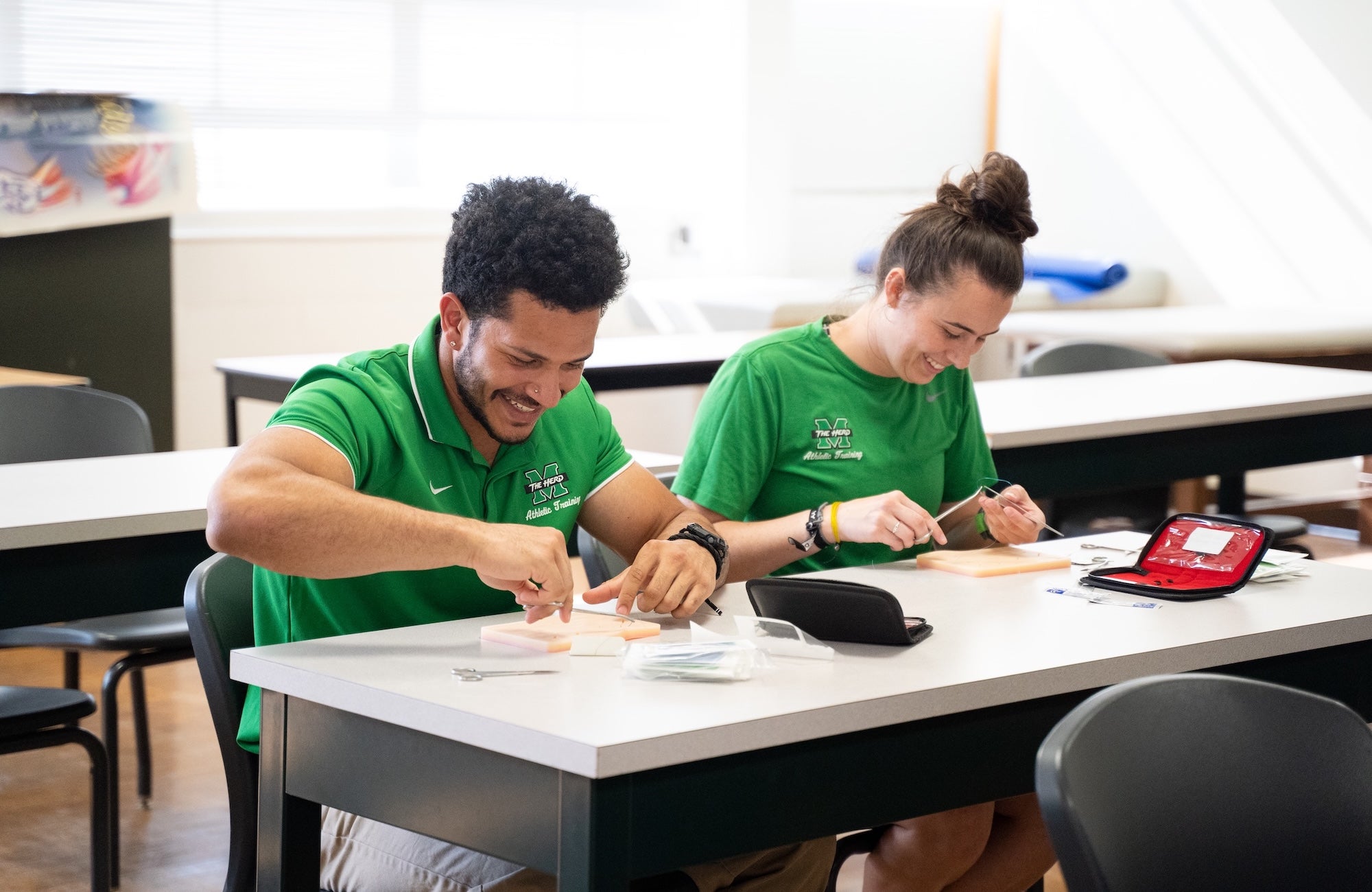 two students working at a stitching activity at a table