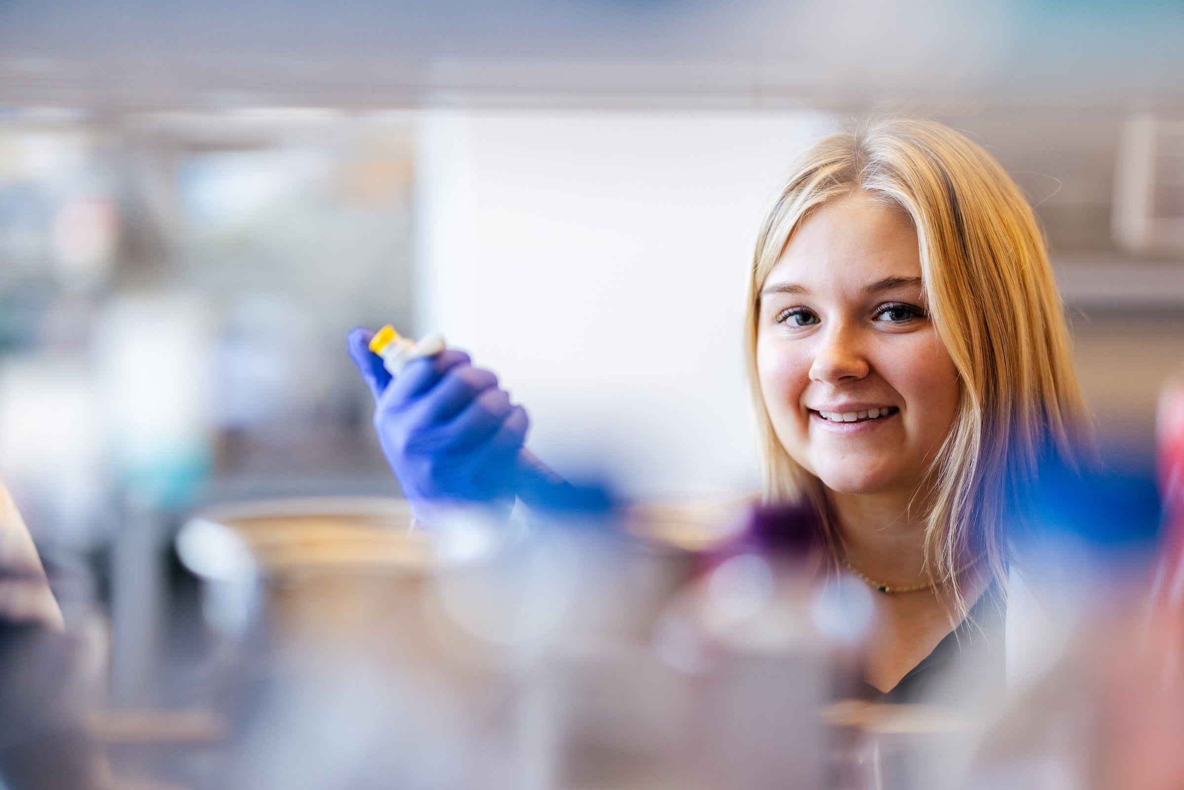 student working in a lab and smiling