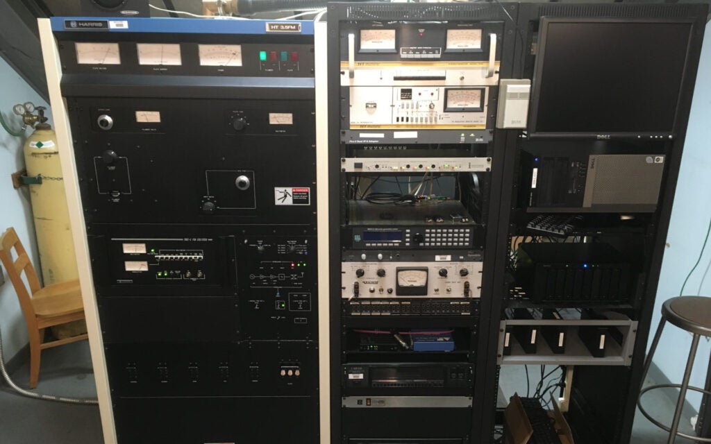 A Harris HT 3.5K FM transmitter to the right, two full equipment racks to the left