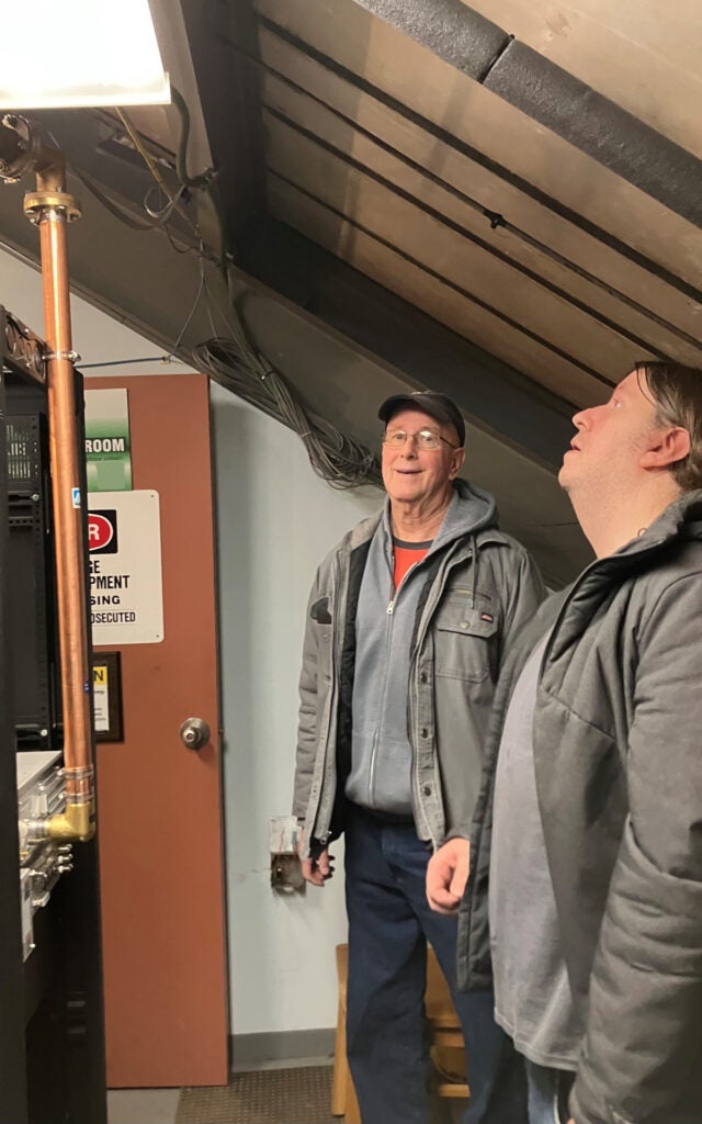 Mike and Dwight inspect the connection between the new and existing transmission line segments.